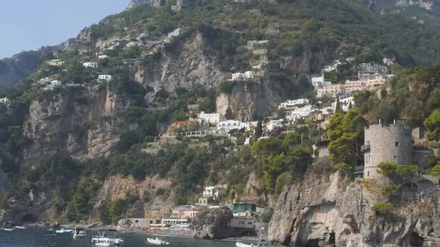 White mediterranean villages on slopes ща mountain. View from sea. Lots of boats along shore