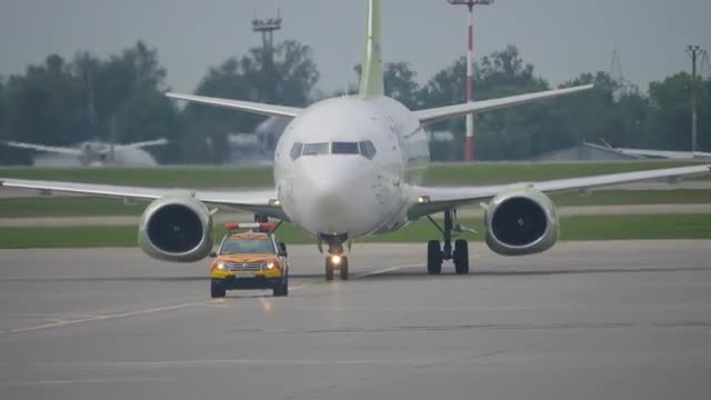 MOSCOW, RUSSIA - JULY 25, 2018: Boeing 737 moves behind follow me car on taxiway in Sheremetyevo air