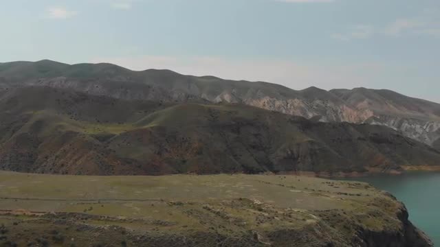 Panning shot of mountain ridge and water surface of lake in Armenian Highlands