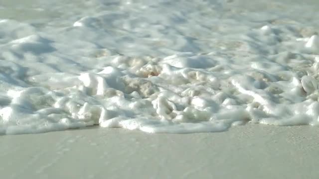 Waves rolling in on the white sand beaches of the Bahamas