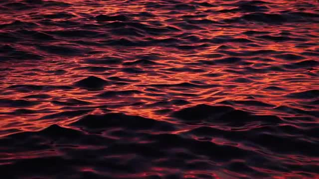 Slow moving sea surface on sunset colors