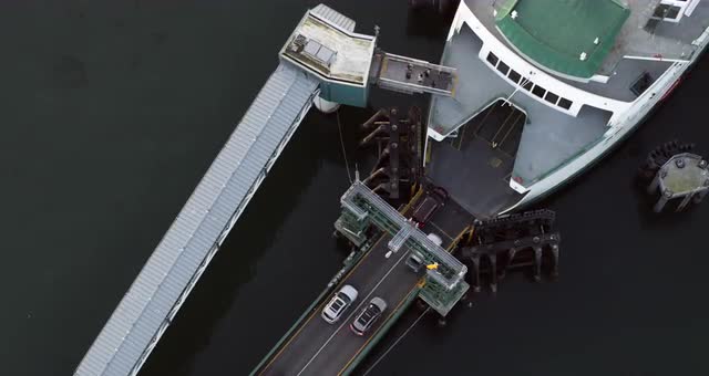 Aerial birds eye view of cars and people entering ferry boat