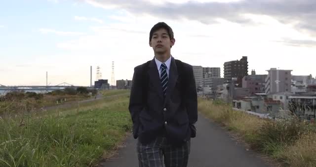 Japanese teenager walking along a river