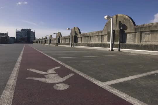 Pedestrian safety walkway sign / man symbol painted on a road surface in a car park (Bristol, UK) 