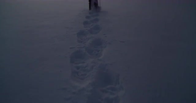 A Man Hiking Across the Frozen Mountains