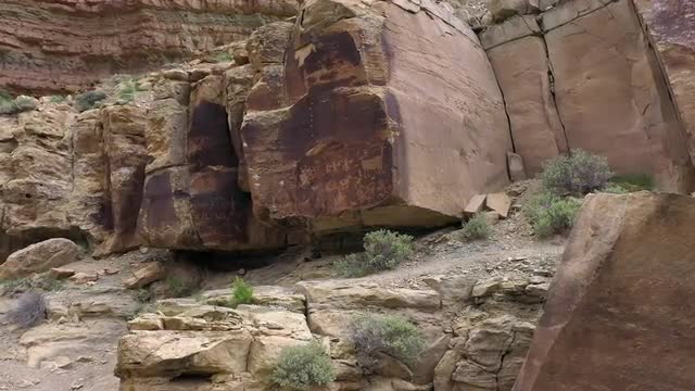 Rotating aerial view of petroglyphs on rock in Utah
