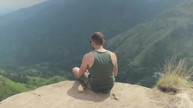 Man sitting on rock cliff