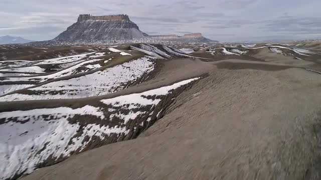 Flying low and fast over rugged desert terrain as snow melts