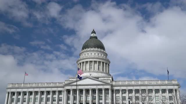American and Utah State Flags waving at the Capitol Building