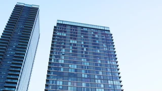 Day to night time-lapse of the exterior of a modern apartment block 