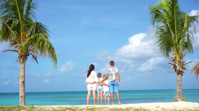 Family on the beach on caribbean vacation have fun