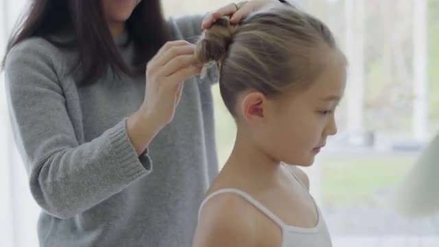 Mother doing daughter's hair