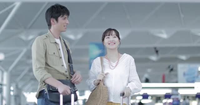 Young attractive and happy Japanese couple at the airport