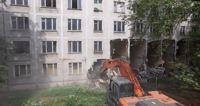An excavator destroys the building with its bucket
