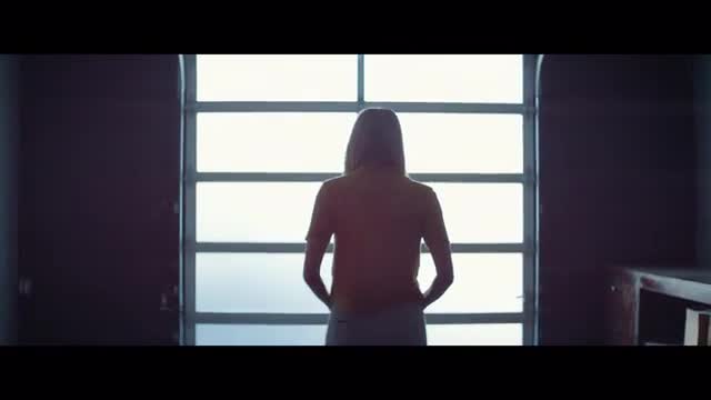 Woman walking towards a window in the morning