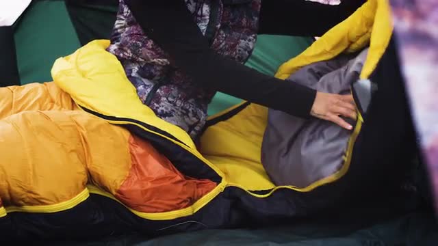 Woman Adjusting Pillow in Sleeping Bag