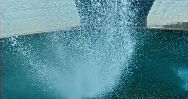 Close up slow motion shot of water following off dam spillway
