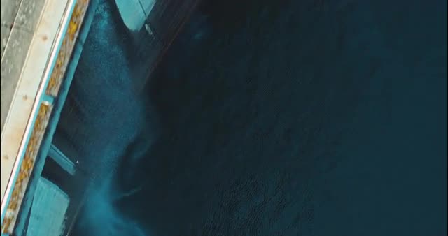 Top down abstract shot of dam, water, birds, reservoir, and river