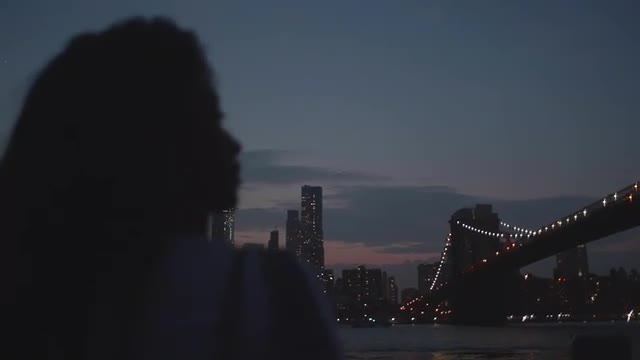 Attractive Woman Views Brooklyn Bridge at Night