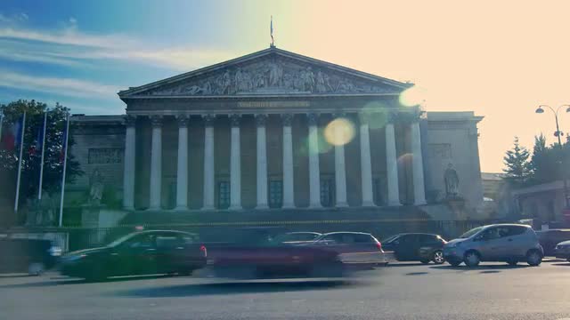 Hyperlapse of the facade of the National Assembly in Paris France from the road full with traffic on