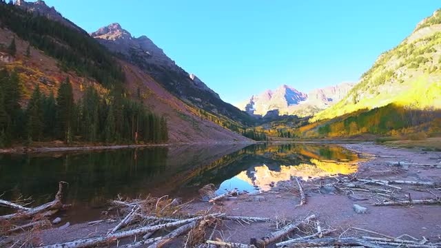 Panning Maroon Bells Colorado at sunrise with colorful autumn aspen foliage