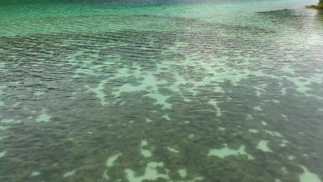 Flying over the colorful aqua water of Cliff Lake viewing the bottom
