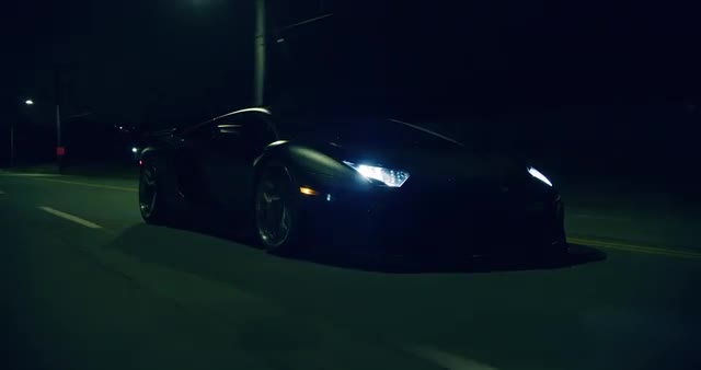 Medium shot of black Lamborghini driving through city streets