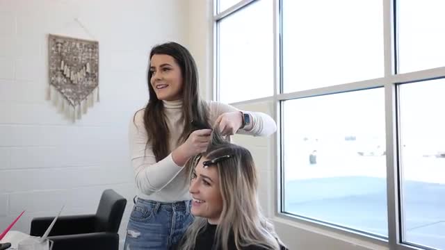 Hairdresser working on woman's hair as they color it