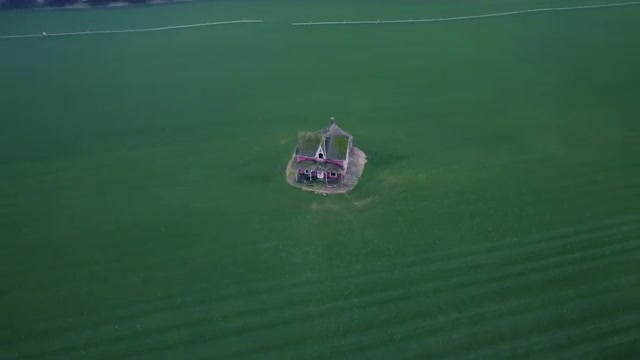 Fly over lonely house standing in the middle the green field