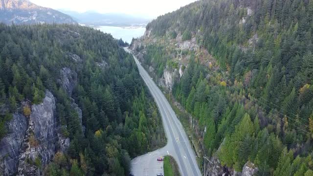 Aerial view of the highway in valley between the mountains and electrical lines