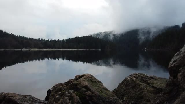 View on the lake from behind the stones in the overcast day