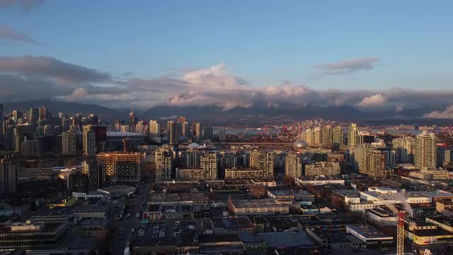 Part of downtown, scenic mountains, Science World and industrial area of Vancouver on sunset