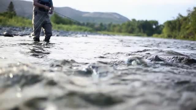Handheld shot in Stream of Fly Fisherman