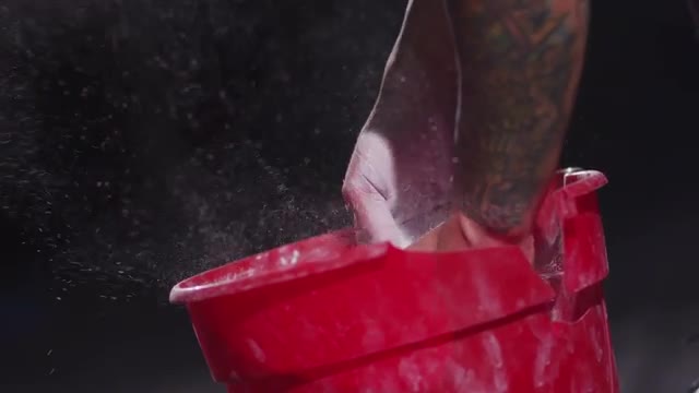 Weight lifter chalking hands, slow motion