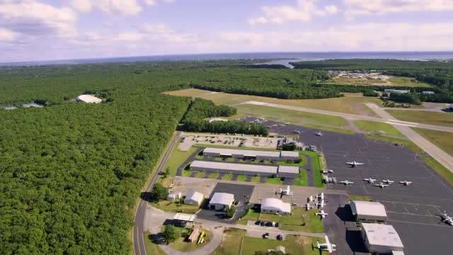 WIDE AERIAL POV over small airport near coast