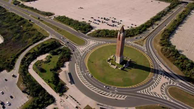 LONG WIDE AERIAL POV over empty parking lot to Jones Beach Water Tower (The Pencil) in center of tra