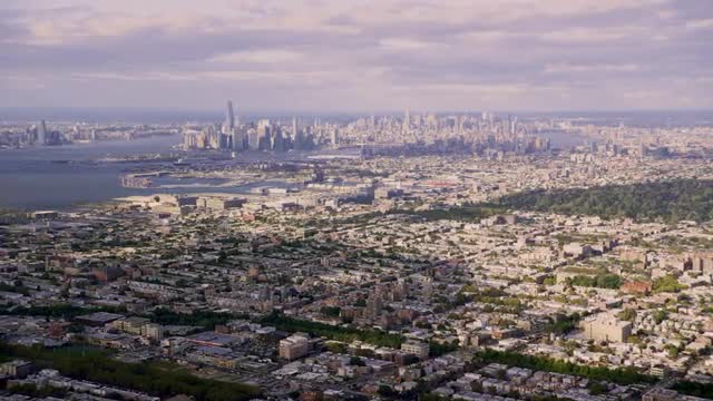 LONG AERIAL sprawling Brooklyn neighborhoods near Green Wood Cemetery with Manhattan skyline in back