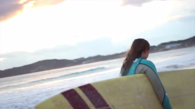 Surfer girl running with the board (magic hour)