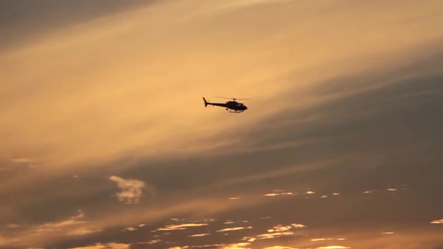 Helicopter Drifts through Sunset