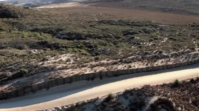 Aerial reconnaissance is being performed on a long stretch of border fence.