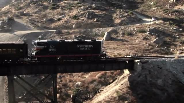 A railroad train crosses over a bridge.