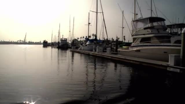 A boat passes through a marina where many boats are docked.