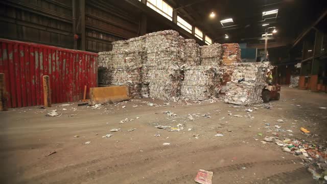 Skip loaders move aluminum blocks at a recycling center.