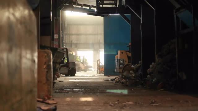 A skip loader picks up trash at a recycling center.