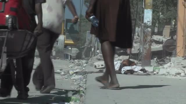 People walk amongst the rubble following a devastating earthquake in Haiti.