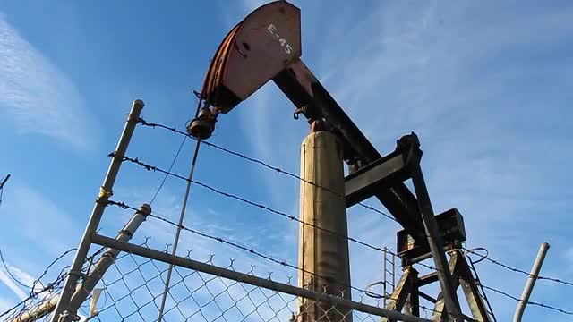 An oil derrick pumps oil.