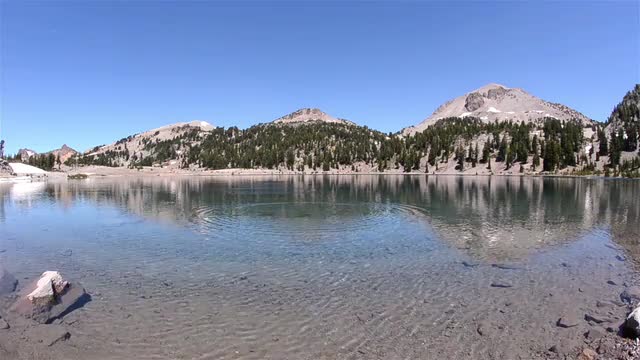 Rock skipping across the clear blue water of Lake Helen below Eagle Peak in Lassen Volcanic National