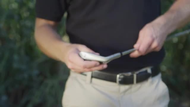 Close-up of a golfer pulling a club from his bag.