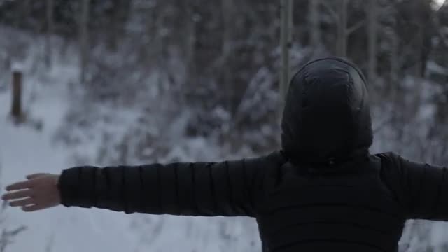 Girl spinning around in snow woods