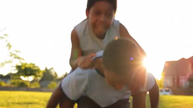 African American boy gives a piggyback ride on a summer day